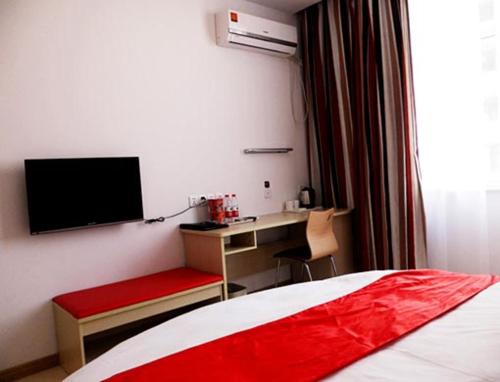 ein Schlafzimmer mit einem Bett und einem Schreibtisch mit einem Monitor in der Unterkunft Thank Inn Chain Hotel Hebei Shijiazhuang Yuanshi Changshan Road in Maoyi