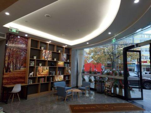 JUNYI Hotel Niongbo Xiangshan Bus Station في Xiangshan: متجر للكتب يحتوي على كراسي وطاولات ورف للكتاب