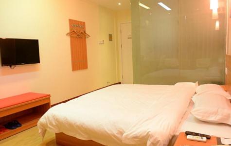 1 dormitorio con 1 cama blanca y TV en Thank Inn Chain Hotel Henan Xinyang Train Station Gongqu Road, en Xinyang