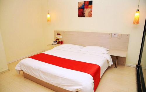 a bedroom with a bed with a red and white blanket at Thank Inn Chain Hotel Shandong Zibo Mingqing Street in Zibo