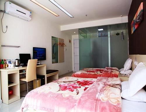 a bedroom with two beds and a desk with a computer at Thank Inn Chain Hotel Jiangsu Yancheng Xiangshui Town Qinghuayuan in Xiangshui