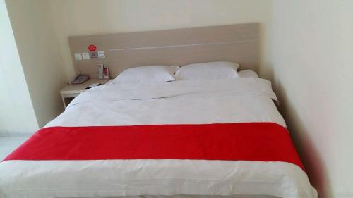 a red and white bed in a small room at Thank Inn Chain Hotel Jiangsu Huaian Lianshui Gaogou Town No.1 Street in Duimatou