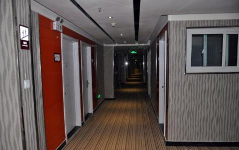 a hallway of an office building with red walls and a long corridor at Thank Inn Chain Hotel Shandong Tengzhou Train Station Wentian Squre in Tengzhou