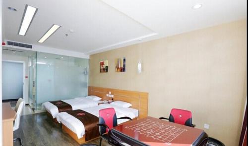 a bedroom with two beds and a table and chairs at Thank Inn Chain Hotel Jiangsu Nanjing Gaochun Market in Gaochun