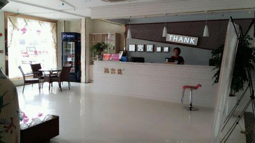 een persoon aan een balie in een restaurant bij Thank Inn Chain Hotel Jiangsu Huaian Lianshui Gaogou Town No.1 Street in Duimatou