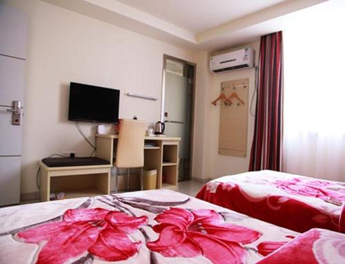 a room with two beds with pink flowers on it at Thank Inn Chain Hotel Jiangsu Yancheng Xiangshui Town Qinghuayuan in Xiangshui