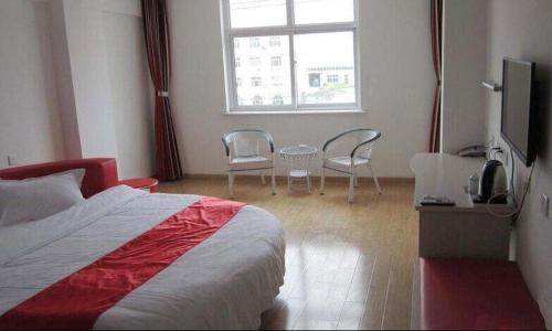 een slaapkamer met een bed en stoelen en een raam bij Thank Inn Chain Hotel Hebei Hengshui Jing County Jingxin Ave in Jingzhou