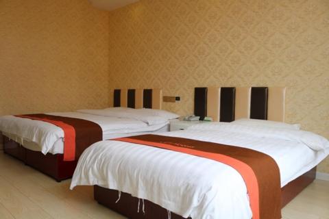 two beds are in a room with at JUNYI Hotel Jiangsu Wuxi Yixing Guibin Avenue in Yixing
