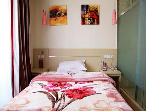 a bedroom with a bed with red flowers on it at Thank Inn Chain Hotel Jiangsu Yancheng Xiangshui Town Qinghuayuan in Xiangshui