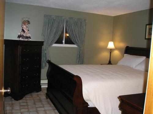 a bedroom with a bed and a dresser and a window at Gulliver's Cove Oceanview Cottages in Centreville