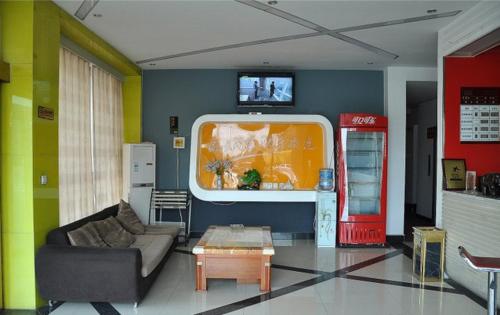 salon z ekspresem do kawy i kanapą w obiekcie Thank Inn Chain Hotel Fei Town Jianshe Road w mieście Feixian