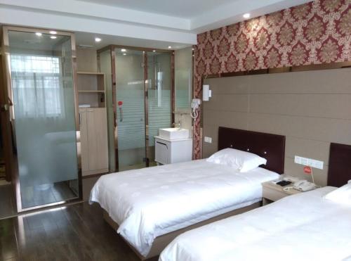 a hotel room with two beds and a shower at JUNYI Hotel Jiangsu Suzhou Mudu Ancient Town in Suzhou