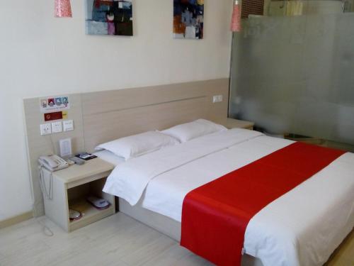 1 dormitorio con 1 cama con manta roja y blanca en Thank Inn Chain Hotel Shandong Rongchengshi Island South Huanghai Road, en Dongshan