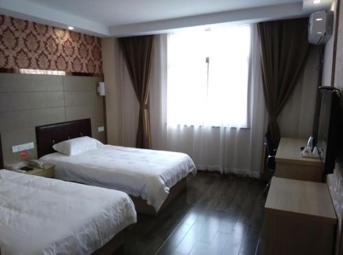 蘇州的住宿－駿怡連鎖江蘇蘇州吳中區木瀆古鎮店，酒店客房设有两张床和窗户。