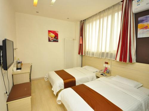 a hotel room with two beds and a flat screen tv at Thank Inn Chain Hotel Shandong Dezhou Jiefang Road in Dezhou