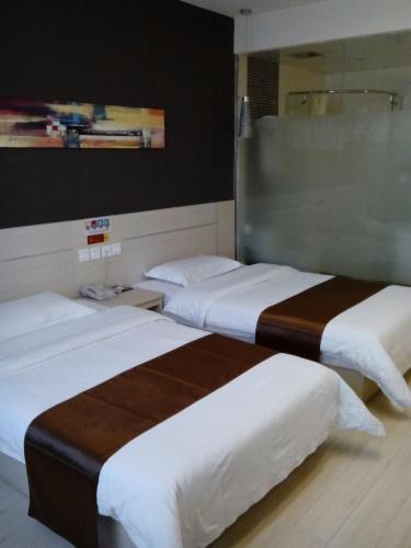 2 camas en una habitación de hotel con sábanas blancas en Thank Inn Chain Hotel Shandong Rongchengshi Island South Huanghai Road, en Dongshan