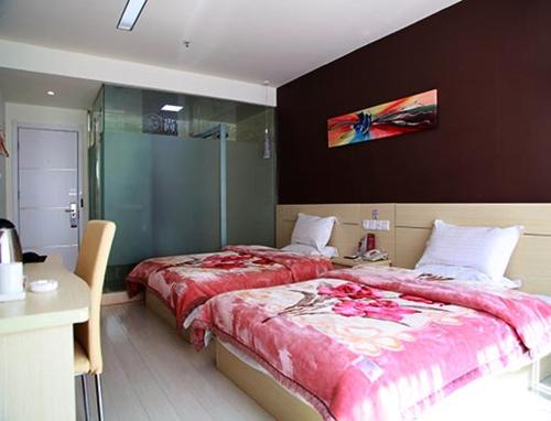 a bedroom with two beds and a glass shower at Thank Inn Chain Hotel Jiangsu Yancheng Xiangshui Town Qinghuayuan in Xiangshui