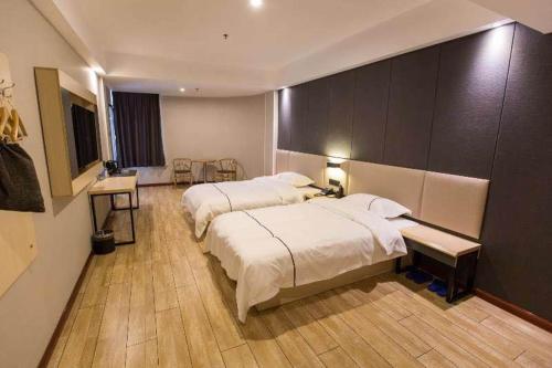 a large bedroom with two beds and a table and a desk at Thank Inn Plus Hotel Hebei Tangshan Road South District Train Station in Tangshan