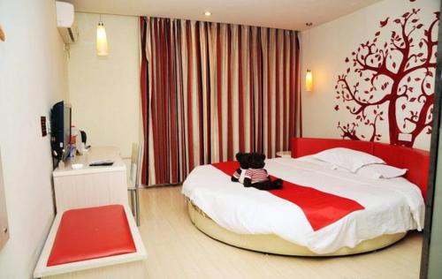 un dormitorio con una cama con un osito de peluche sentado en ella en Thank Inn Chain Hotel Shandong Zibo Mingqing Street, en Zibo