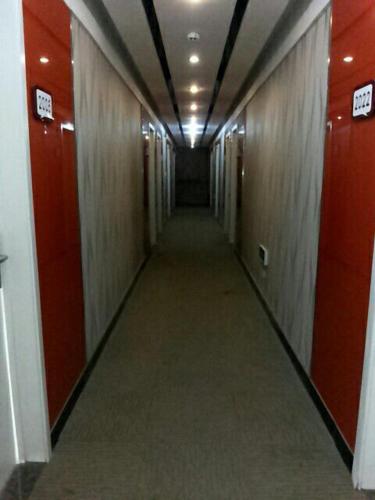 a long hallway with red doors and a long corridor at Thank Inn Chain Hotel Shandong Dezhou South City in Dezhou