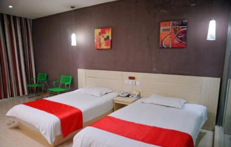 ein Hotelzimmer mit 2 Betten mit roter und weißer Bettwäsche in der Unterkunft Thank Inn Chain Hotel Shandong Ningyang West Street in Ningyang