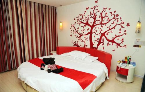 un osito de peluche sentado en una cama en un dormitorio en Thank Inn Chain Hotel Shandong Zibo Mingqing Street, en Zibo