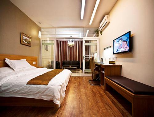 Thank Inn Chain Hotel Jiangsu Yangzhou Shaobo Grand Canal في يانغتشو: غرفة نوم مع سرير ومكتب مع جهاز كمبيوتر