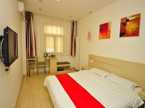 a bedroom with a red and white bed and a desk at Thank Inn Chain Hotel Shandong Dezhou Jiefang Road in Dezhou