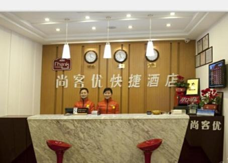 dos personas de pie detrás de un mostrador en un restaurante en Thank Inn Chain Hotel Jiangsu Yangzhou Shaobo Grand Canal, en Yangzhou