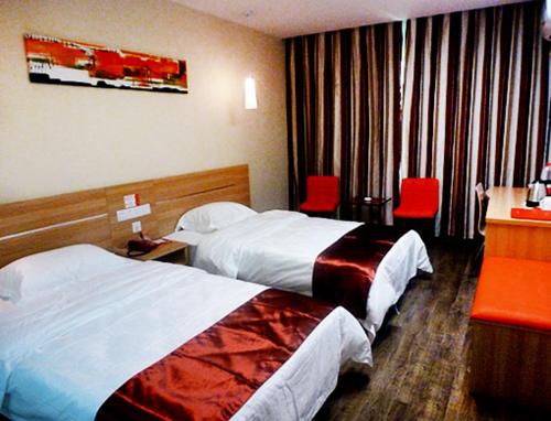 Thank Inn Chain Hotel Henan Puyang Taiqian Train Station في Dayuchen: غرفة فندقية بسريرين وكراسي حمراء