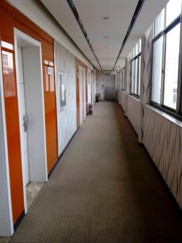 an empty hallway in an office building with windows at Thank Inn Chain Hotel Shandong Rongchengshi Island South Huanghai Road in Dongshan