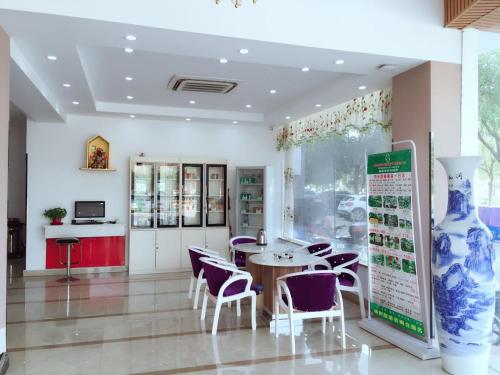 een restaurant met een tafel en stoelen in een kamer bij Thank Inn Chain Hotel Jiangsu Suzhou likou Metro Station in Suzhou