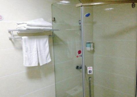ein Bad mit einer Dusche und einer Glastür in der Unterkunft Thank Inn Chain Hotel Henan Puyang Taiqian Train Station in Dayuchen