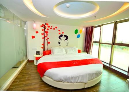a bedroom with a large bed with hearts on the wall at Thank Inn Chain Hotel Guangdong Meizhou Mei County Lijiangwan in Meizhou