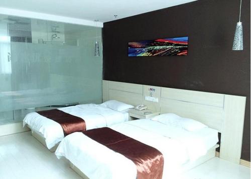 two beds in a room with a tv on the wall at Thank Inn Chain Hotel Jiangsu Jiangyan Pedestrian Street in Taizhou