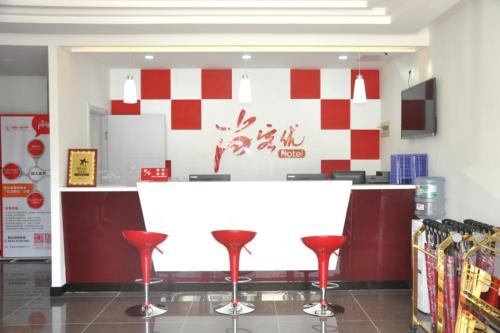 青島市にあるThank Inn Chain Hotel Shandong Qingdao Junfeng Roadの赤い便器を備えた店のカウンター