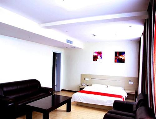 - une chambre avec un lit, un canapé et une table dans l'établissement Thank Inn Chain Hotel Shanxi Jinzhong Shouyang Chaoyang Road, à Shouyang