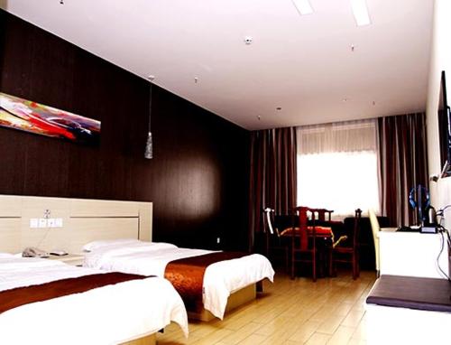 une chambre d'hôtel avec deux lits et une salle à manger dans l'établissement Thank Inn Chain Hotel Shanxi Jinzhong Shouyang Chaoyang Road, à Shouyang