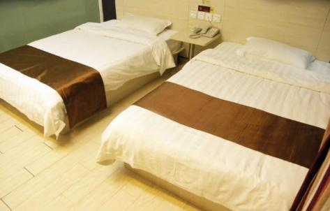 a hotel room with two beds and a table at Thank Inn Chain Shandong Zaozhuang Taierzhuang Gucheng Development Area Rapid Bus Station in Zhaozhuang