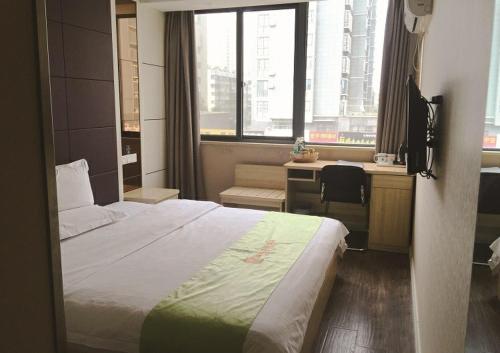 Pokój hotelowy z łóżkiem, biurkiem i oknem w obiekcie JUNYI Hotel Jiangsu Xuzhou Middle Xiyuan Road w mieście Xuzhou