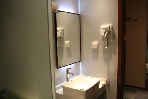 a bathroom with a sink and a mirror at Thank Inn Plus Hotel Fengxian Xidu in Xidu