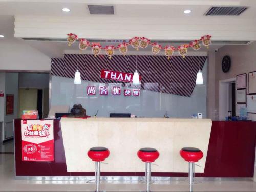 a restaurant with a counter with red stools at Thank Inn Chain Hotel Shanxi Yuncheng Jiang County Wengong Road in Weizhuang
