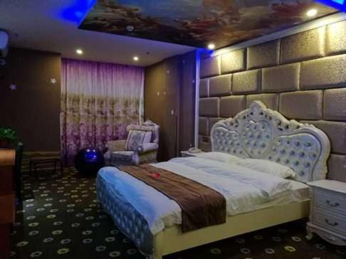 ein Schlafzimmer mit einem großen Bett und einer Steinwand in der Unterkunft Thank Inn Chain Hotel Zhejiang Huzhou Changxing Town Qingfang City in Jiapu