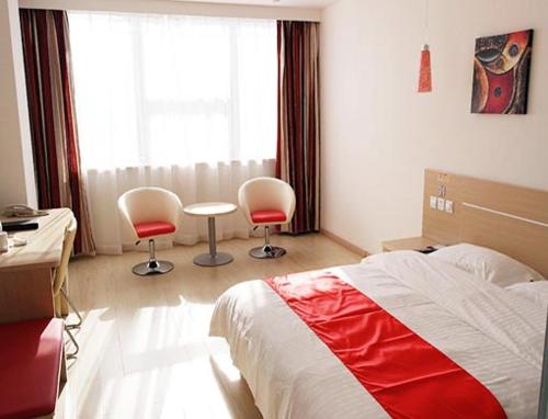 ein Schlafzimmer mit 2 Stühlen, einem Bett und einem Fenster in der Unterkunft Thank Inn Chain Hotel Shandong Ningyang West Street in Ningyang