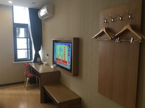 Cette chambre dispose d'un bureau et d'une télévision murale. dans l'établissement Thank Inn Chain Hotel Zhejiang Hangzhou West Lake District, Sandun County, Oulubao Plaza, à Libu