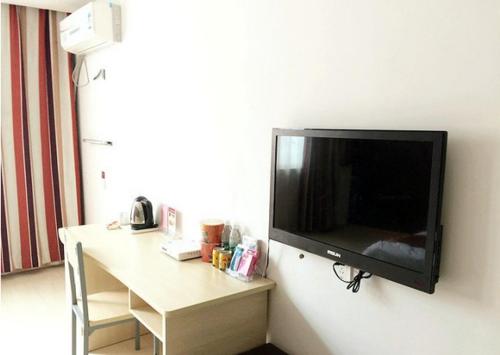 a flat screen tv hanging on a wall at Thank Inn Chain Hotel Jiangsu Jiangyan Pedestrian Street in Taizhou