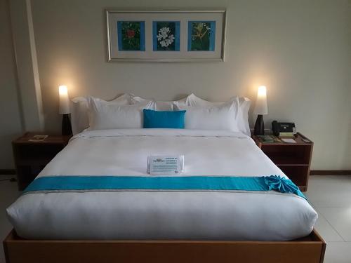 a large bed in a hotel room with two lamps at The Sanctuary Hotel Resort Spa in Port Moresby