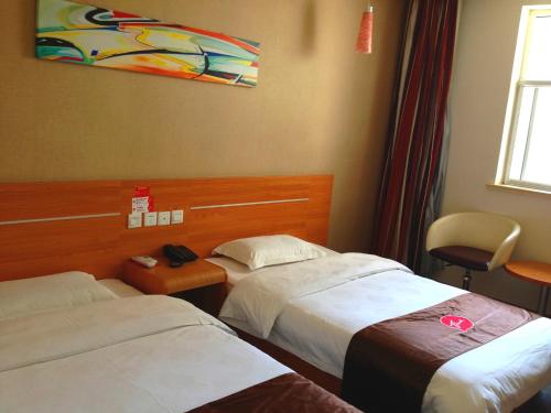 a hotel room with two beds and a chair at Thank Inn Chain Hotel Shanxi Shangluo Shanyang Nanxin Street in Shanyang