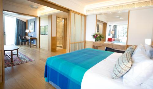 a hotel room with a large bed and a desk at Columbia Beach Resort in Pissouri