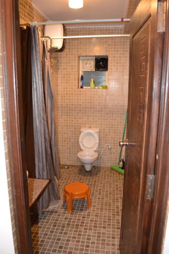 a bathroom with a toilet and a stool in it at Ocean Shores Hospitality in Candolim